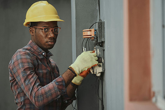 An electrical engineer repair a fuse box. Sometimes what we play around with can lead to an incredible journey. John's interest in wires led him to bring light to his people.