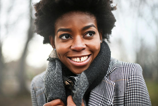 A smiling black girl with a scarf on the neck Despite the tragedies she faced, Maya's life has become joyful and inspiring.