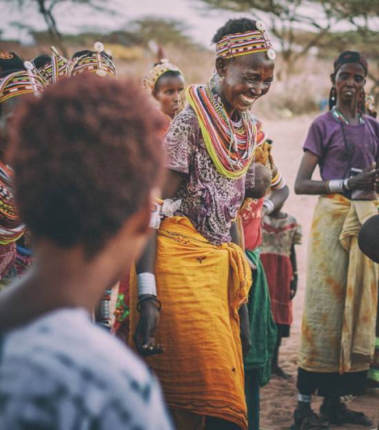 A woman smiled and dancing in tribe A tribe elder performing a cultural dance with others