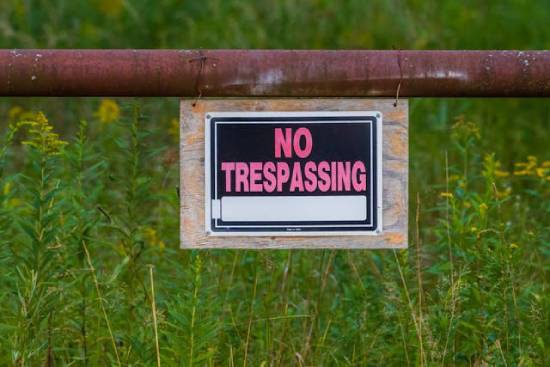 A 'No Trespassing' sign in front of a field.