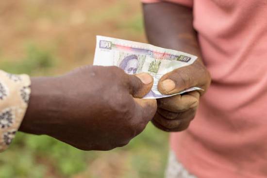 Exchanging Kenyan Money Someone handing a Kenyan paper currency to someone else