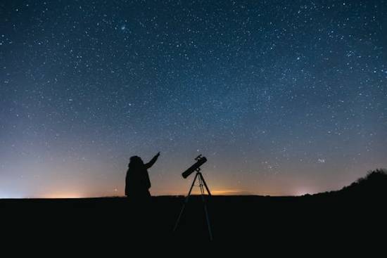 Looking at Night Stars With Telescope A person out under the starry sky with a telescope