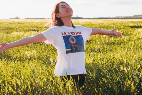 Woman in nature feeling fresh air A woman in a field with her arms outstretched as she takes a deep breath of fresh air.