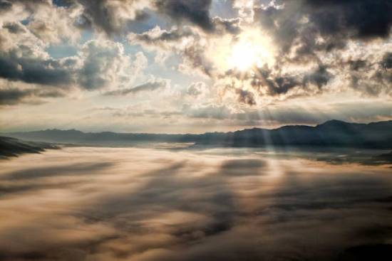 Rays of sunlight piercing clouds, illustrating how hope can pierce our clouds of discouragement.