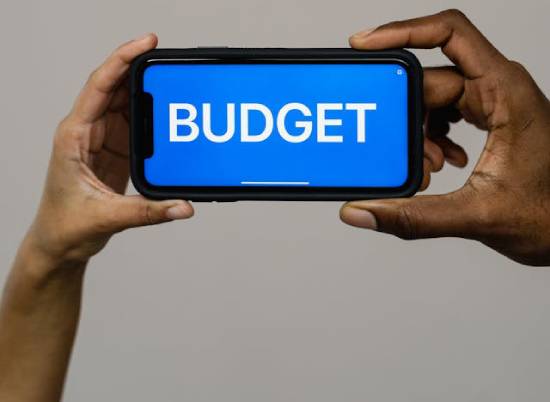 Phone with the word Budget written on the screen A phone with the word "BUDGET" on the screen, emphasizing the importance of budgeting.
