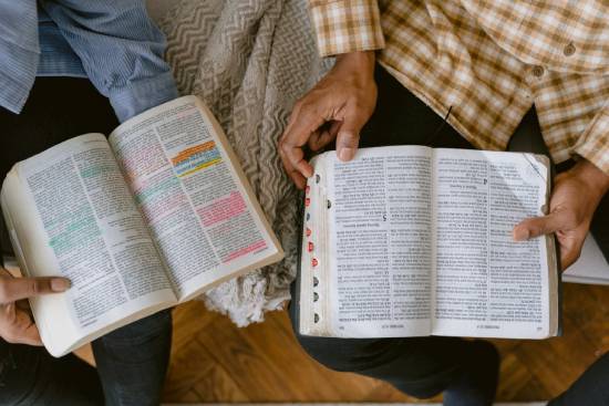 Two people reading their Bibles together, illustrating how turning to Scripture can help encourage us.