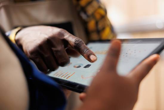 A man pointing to data charts on a digital tablet