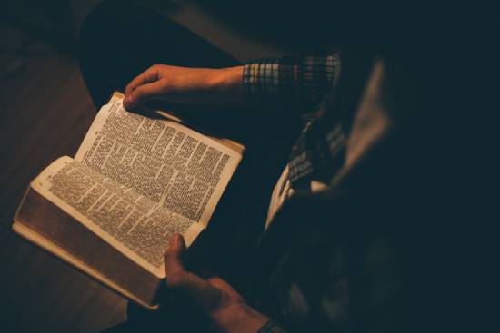 A Person Reading the Bible A person reading the Bible to find examples of forgiveness and new beginnings.