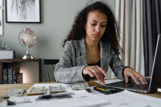 A woman Tracking her Finances A woman tracking her income, expenses, and savings to know where everything goes and find any loopholes.