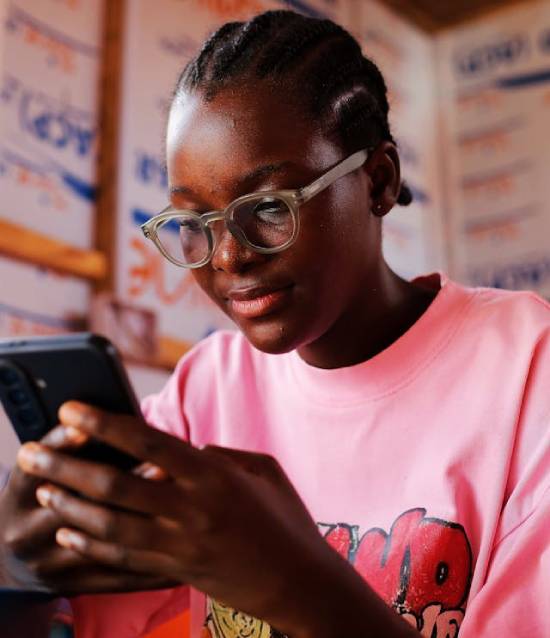 Teenager Reading on a Smartphone A teenager reading an article about red flags in friendship on her smartphone.
