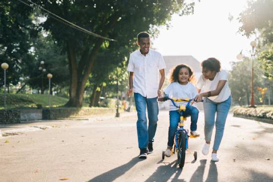 A Couple Training Their Daughter to Ride a Bike A couple training their daughter to ride a bike as part of their way of spending more time together.