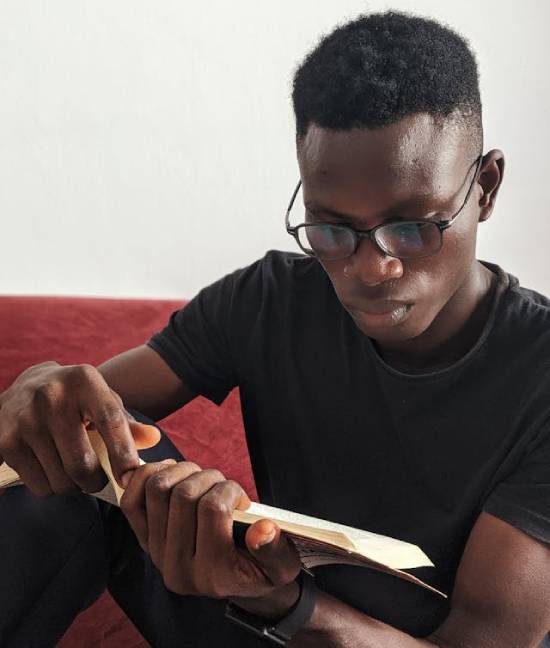 A man reading Bible promises to strengthens his faith as he waits for God to come through for him in his financial struggles.