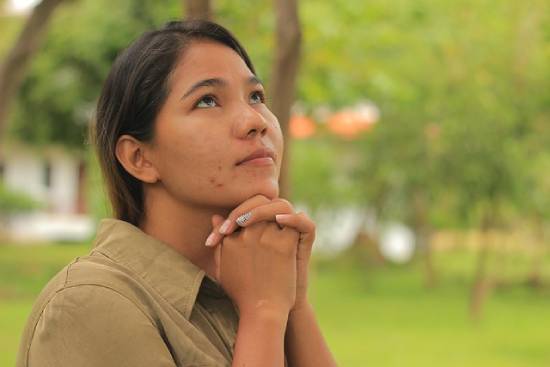A woman seeking God in prayer in her season of financial hardships.