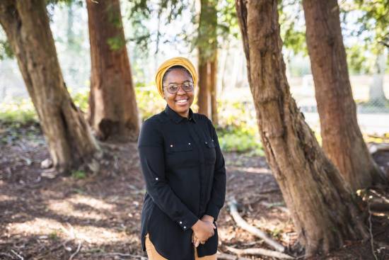 A calm and hopeful woman in the woods after a session of prayer.