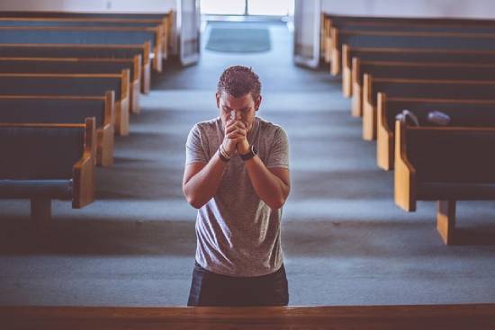 A man seeking God in prayer in a church.