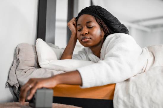 A woman doing gentle stretches on the bed before waking up to help her achieve mental wellness.