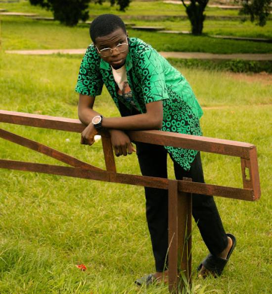 A Mna Leaning on a Metallic Barrier A man leaning on a metallic barrier in a field gazing over yonder.