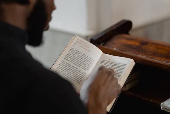 A man studying the Bible to discover the relationship between faith and stewardship.