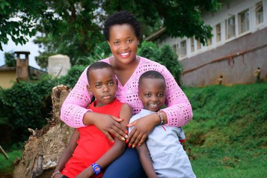 Mother Embracing Her Sons A smiling mother in a pink knitted top embracing her two sons.