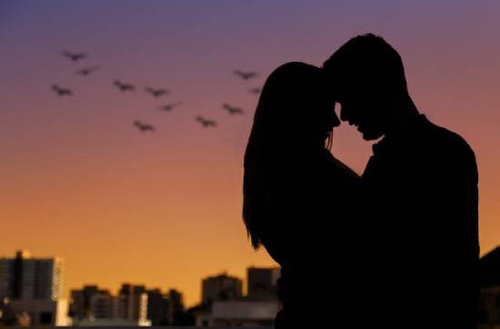  A silhouette photo of a couple embracing during the golden hour.