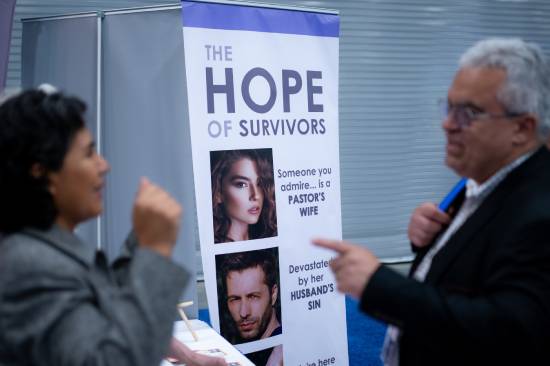 Two adults going through a catchy and appealing conference banner.