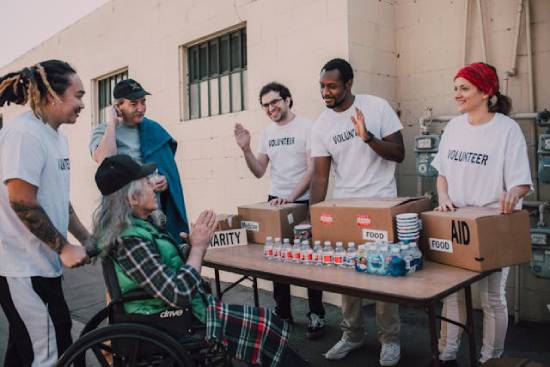 Community Service Volunteers Volunteers happily helping distribute foodstuffs and other amenities during a community service.