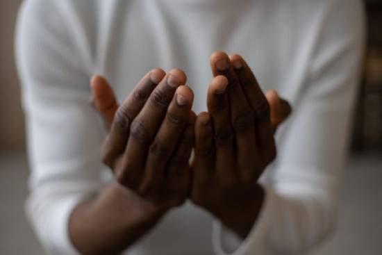 A man putting his hands together in reverence during a session of prayer.