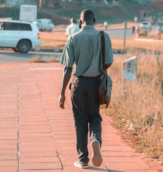 A man carrying a handbag walking to work.