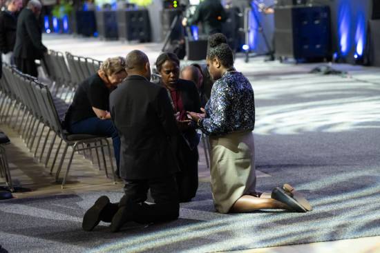 People helping other to pray in their prayer groups.