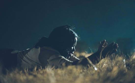 A woman lying prostrate in surrender to God while making her prayers.