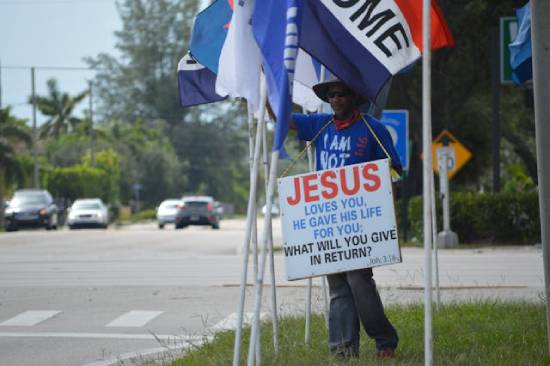 Man Holding a Placard A man in blue t-shirt holding a placard witnessing for Jesus Chrsit.