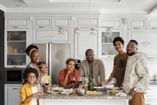 Family in the Kitchen A family posing for a photo in the kitchen after preparing a meal together.
