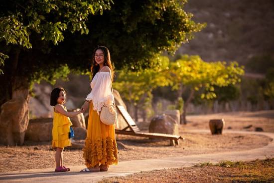 A mother and daughter pausing for a photo during an evening nature walk.