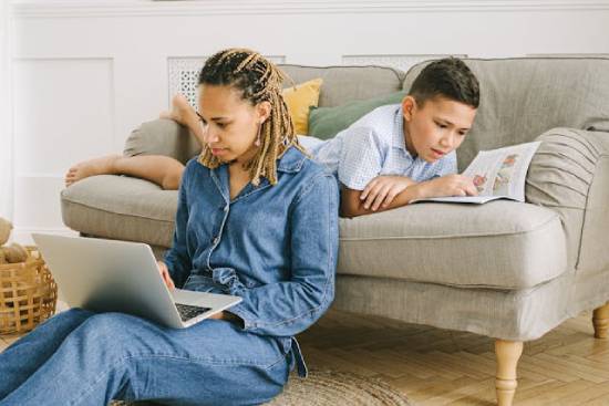 A mother in denim sets searching for online resources to help her son grow spiritually.
