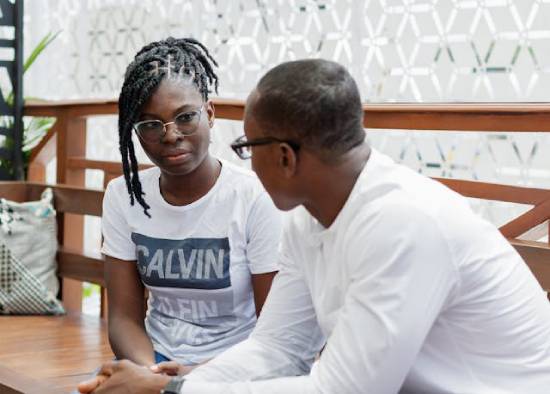 A couple having safe conversions while sitting next to each other in a cafe.