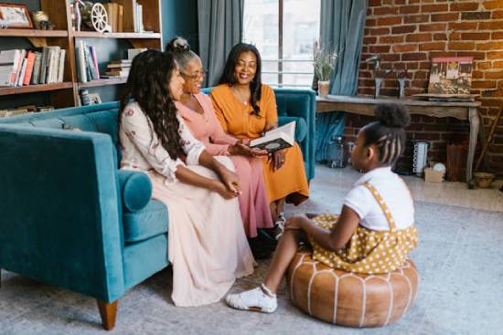 Three adult ladies having a Bible study in the living room while a little girl listens keenly.