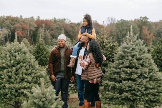 Family friends spending time together in a Christmas tree farm.