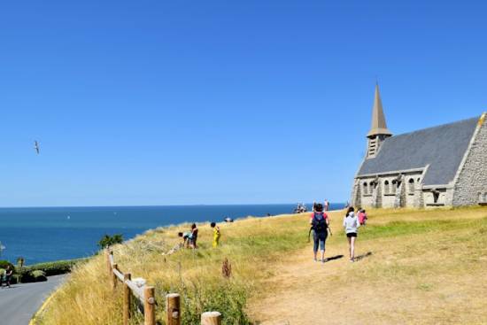 People doing different activities in a church compound situated next to the ocean.