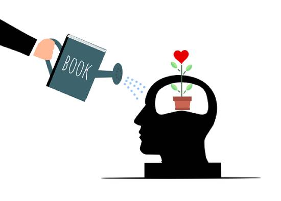 An illustration of self-care and mental health with a hand holding a book and pouring information into one's mind.