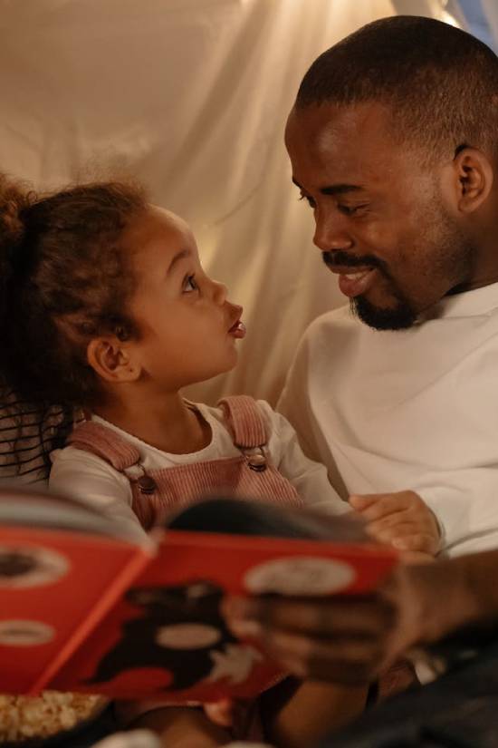 A happy smiling father talking a bubbly daughter.