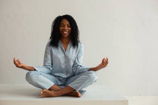 A woman in sky-blue sleepwear meditating.