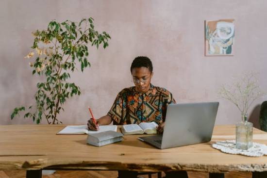 A man in aztec print button down shirt studying the Bible and making notes about preparation and trusting God.