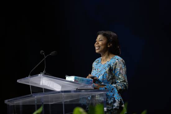 A female preacher makes a presentation on trusting in the Lord froma podium.