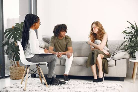 An emotionally distressed couple seeking counseling service from a professional marriage counsellor.