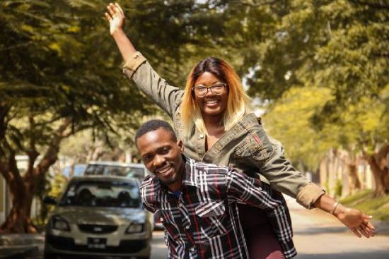 A man carrying his wife on his back out together on a date.