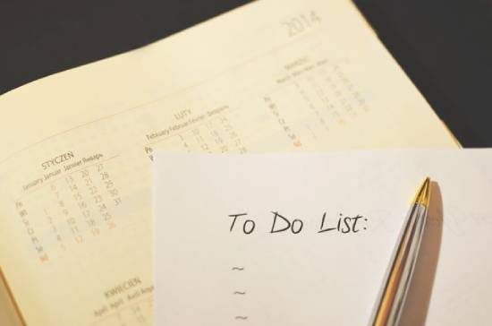 A pen and a notebook with 'to-do list' on a calendar.