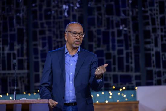 Pastor Delivering a Training A pastor in a navyblue blazer and skyblue shirt delivering a training on divine calling.