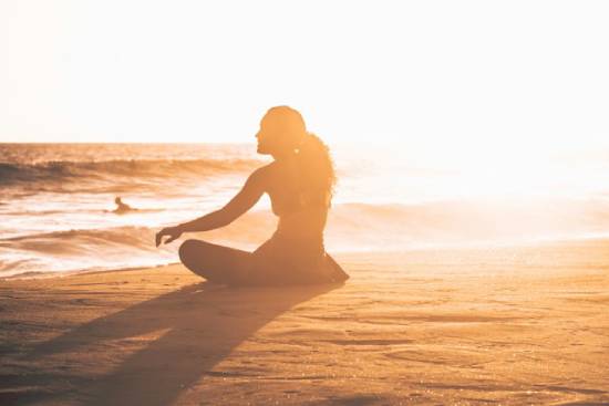 Woman Sitting by the Seashore Woman sitting by Seashore at sunset.